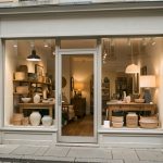 Devanture réaliste d’une boutique de décoration à Auxerre, avec une vitrine présentant des meubles et des luminaires dans une rue commerçante calme.
