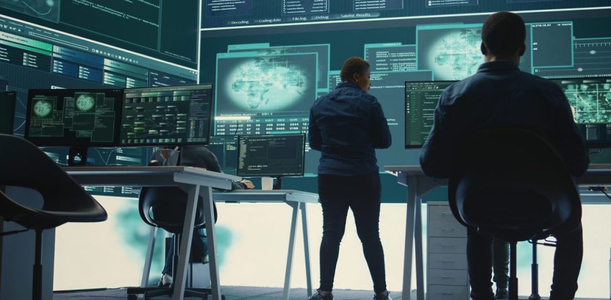 Équipe informatique surveillant des écrans de sécurité dans les locaux d’une entreprise
