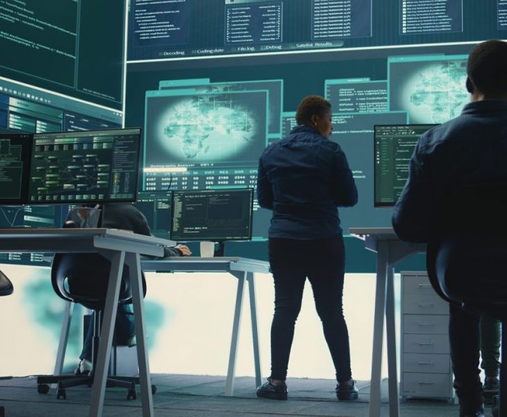 Équipe informatique surveillant des écrans de sécurité dans les locaux d’une entreprise